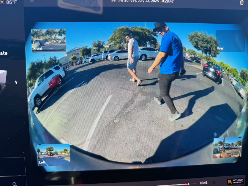 Tesla Sentry Mode capture — person in indoor parking garage reacting to Big Nutz